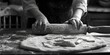 Person preparing dough on a table, ideal for food and cooking related projects