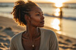 Entspannte junge afroamerikanische Frau genießt die warme Sonne am Strand im goldenen Licht