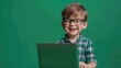 A young boy with glasses smiling while using a laptop. Suitable for educational and technology concepts