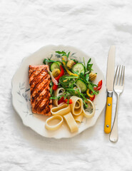 Wall Mural - Balanced lunch - grilled salmon, pasta and fresh vegetable salad on a light background, top view