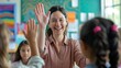 © Usman - Happy teacher and schoolgirl giving high five during class at school