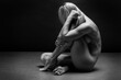 Art black and white photo of naked beautiful woman. Beauty nude yoga girl posing on black background. 