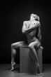 Art black and white photo of naked beautiful woman. Beauty nude yoga girl posing on black background. 