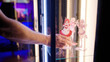 Person hand put cute red anime maid girl figure inside the glass cabinet