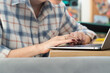 © Vitaliy - Close-up shot of a woman's hand working on a laptop keyboard. Concept of distance work, online learning and internet surfing