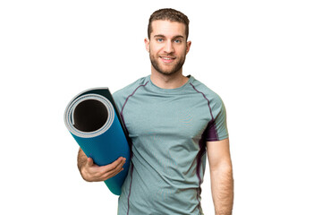 Wall Mural - Young sport man going to yoga classes while holding a mat over isolated chroma key background smiling a lot