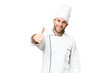 © luismolinero - Young blonde man Chef over isolated chroma key background with thumbs up because something good has happened