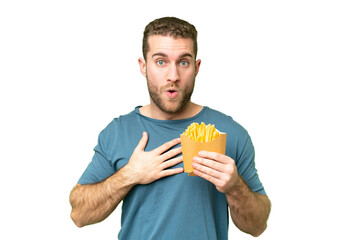 Wall Mural - Young handsome blonde man holding fried chips over isolated chroma key background surprised and shocked while looking right