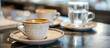 Espresso served in classic ceramic cups with a side of sparkling water is customary