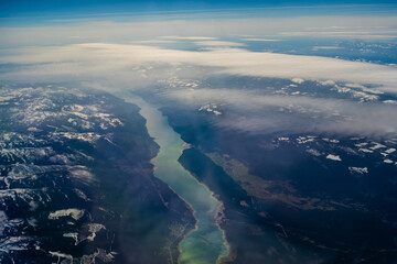 Wall Mural - view from the airplane window at the setting sun and mountains crossed by clouds, usa