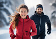 A man and woman in outerwear running in snow with smiles on their faces