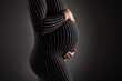 Elegant Pregnant Woman Embracing Her Belly in Striped Dress