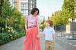 © boytsov - Caucasian young beautiful happy mother and cute small son walking the street and looking at each other. Woman and little boy smiling, talking and having vacations. High quality photo