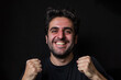 © mila103 - A man with a big smile and a fist pump on a black background