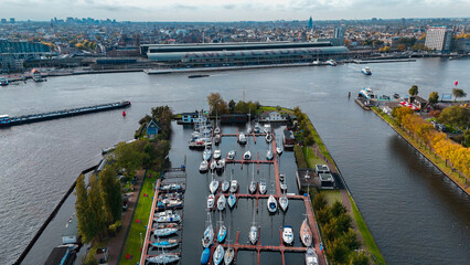 Wall Mural - Aerial drone view Amsterdam Central Train Station with Amsterdam sign on roof. Bird's eye view autumn cityscape