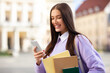 © Prostock-studio - Student pretty young woman smiling at phone outdoors