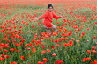 girl in red clothes dancing in the middle of the poppy field