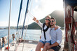 Happy couple traveling on yacht at sea. Man and woman hugging and having fun, adventures and freedom. Travelers sailing, enjoying sunset and summer vacation. Tourists on sailboat. Lifestyle moment
