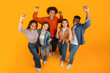 © Prostock-studio - Friends with raised fists in excitement on orange background