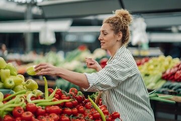 Side view of happy woman buying fresh vegetables at farmers market.