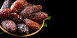 Dates fruit. Date fruits with palm tree leaf, in a wooden bowl, isolated on black background. Medjool dates close up. Border design