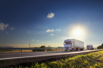 Wall Mural - Cargo truck driving through landscape at sunset