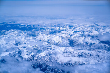 Wall Mural - top view of mountains with snow and clouds.