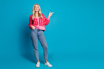 Poster - Full size photo of nice person dressed knitwear jumper jeans indicating at proposition empty space isolated on blue color background