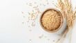 © chanidapa - Coarse brown rice in wooden bowl with paddy rice isolated on white background, top view, flat lay.