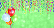 Green blurred background with balloons and different colored confetti and streamers for party time. Empty space for text