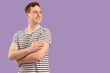Young man with applied medical patch on purple background. Vaccination concept