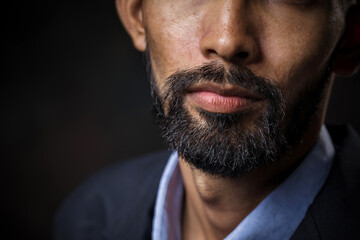 Close-up of business bearded man's face in a black studio, background.