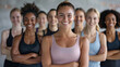 An inclusive and diverse group of women confidently posing together in a gym environment.
