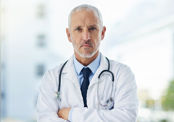 Canvas Print - Doctor, serious and portrait of mature man in a hospital at a cardiology clinic with arms crossed. Professional, medical employee and stethoscope with healthcare, wellness and cardiologist consultant