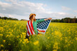 Woman patriot with american flag enjoying sunset at field. 4th of July. Independence Day. 