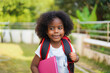 © Art_Photo - Back-to-school season with african american kid girl on the move with book and colorful school backpack, children, education, student go to school, study and learn at primary school
