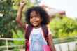 © Art_Photo - Back-to-school season with african american kid girl on the move with book and colorful school backpack, children, education, student go to school, study and learn at primary school
