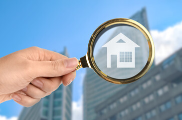 Wall Mural - Woman holding magnifying glass with illustration of house against building, closeup. Search for apartment