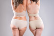 Two overweight women with cellulitis, fat flabby back, hips and buttocks on gray background, obese female body, liposuction, plastic surgery and body positive concept
