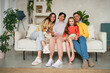 © Westend61 - Happy family sitting with dog on sofa at home