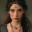 A woman with a crescent moon on her forehead wears a necklace and headband