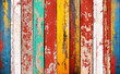 Texture of vintage wood boards with cracked paint of white, red, yellow, green and blue color. Horizontal retro background with old wooden planks of different colors