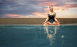 Wellness spa, vacation and yoga meditation concept. Pretty young woman in swimsuit sitting in lotus position near the swimming pool.