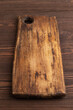 Empty rectangular wooden cutting board on brown wooden. Side view