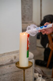 Fototapeta Miasta - igniting of babtism candle on the easter candle