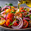 Olive oil cascades onto a vibrant tomato salad, mingling with slices of red onion, creating a tantalizing blend of flavors and textures that elevate the freshness of the dish.