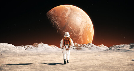 Wall Mural - astronaut on an alien planet walking to his base. mars is visible. space related majestic scene.