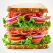 A towering deli sandwich with layers of fresh vegetables and ham on oat bread.