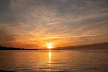 Wall Mural - Stunning landscape of a tranquil body of water reflecting the vibrant colors of sun in Newfoundland