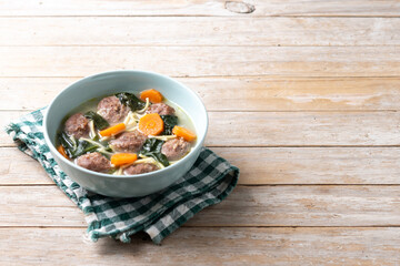 Wall Mural - Italian Wedding Soup with meatballs and spinach on wooden table. Copy space